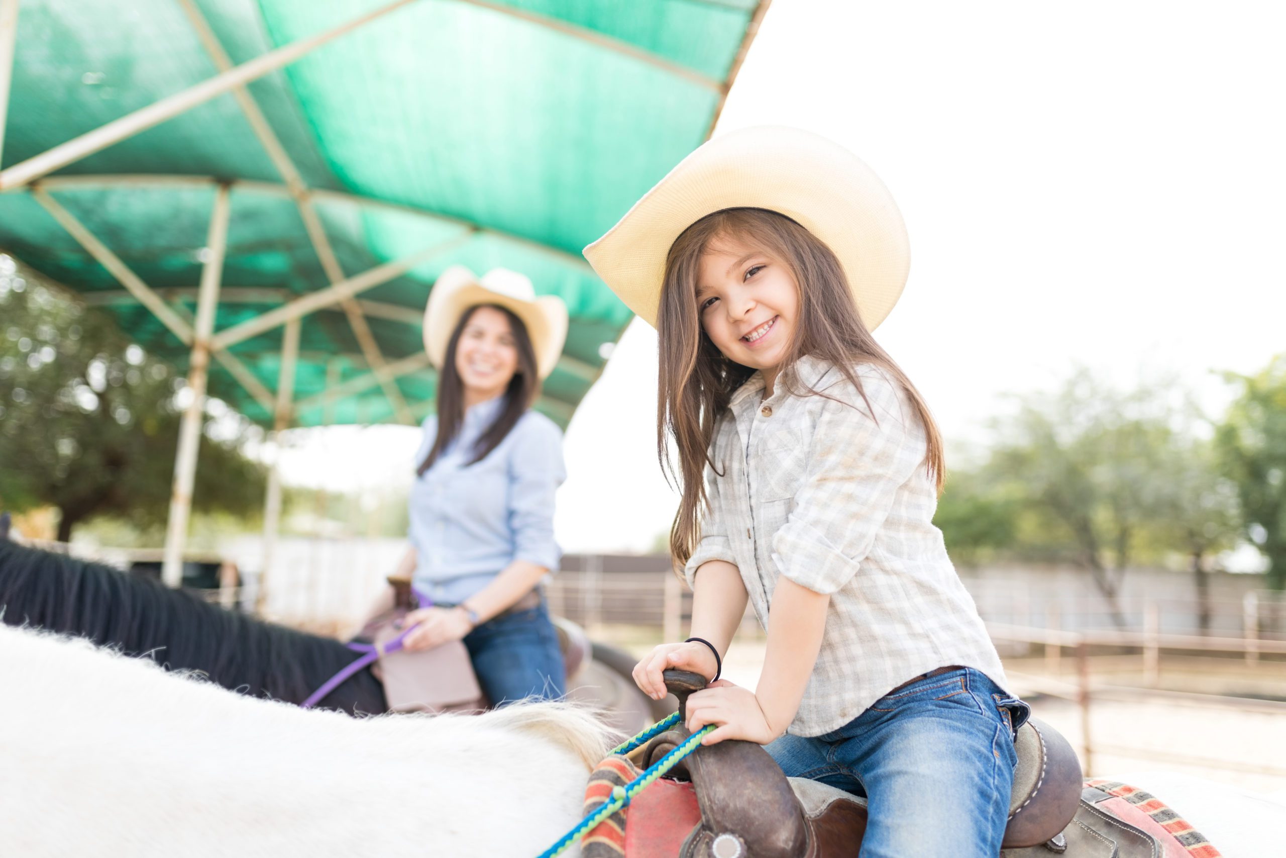 Girl On Horse During Hippotherapy Session young girl riding horse with her mom