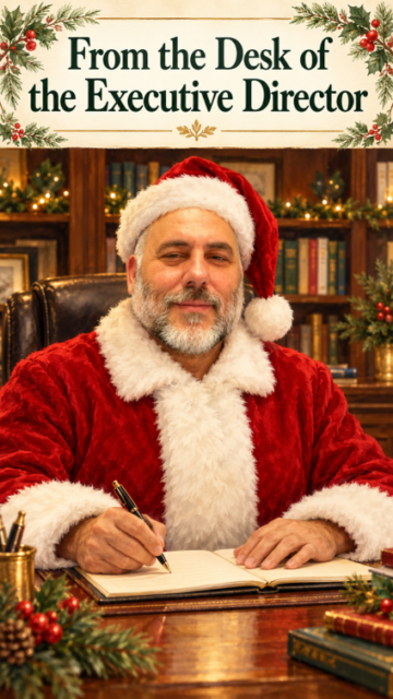 LIFTT Director Carlos Ramalho dressed in a Santa Suit sitting behind a desk with text above reading 