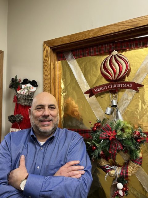 LIFTT executive director Carlos Ramalho stands next to his office door decorated for the holidays