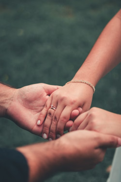 Intimate moment of a couple holding hands, symbolizing love and connection in an outdoor setting